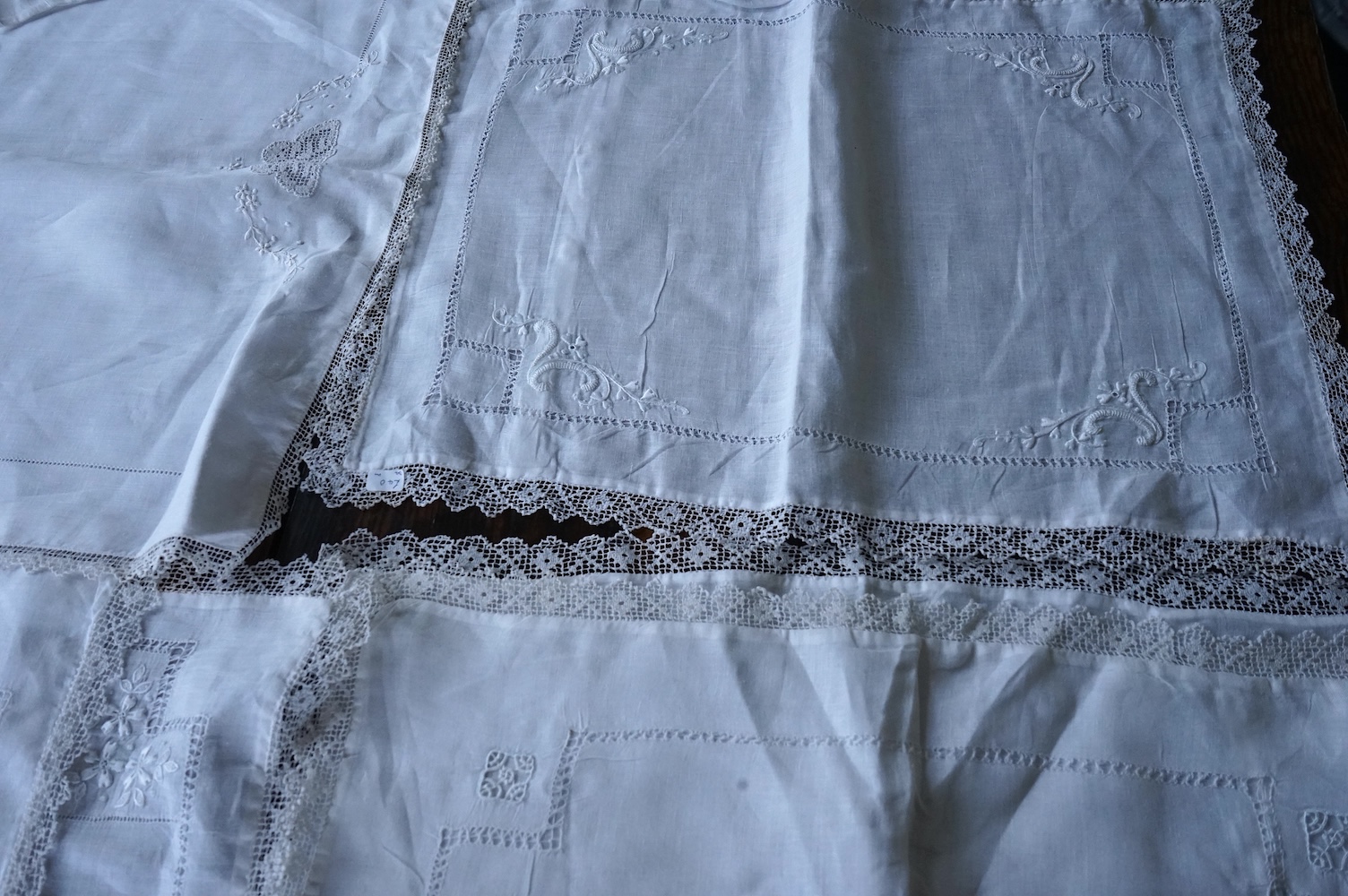 Ten fine linen baby’s pillowcases, eight inset and edged with fillet lace, together with a large fine linen red bordered 19th century ladies kerchief, and three other items. (14) Kerchief 54cm x 58cm. Condition - all ite